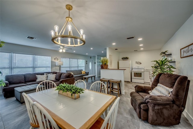 dining space featuring ceiling fan with notable chandelier