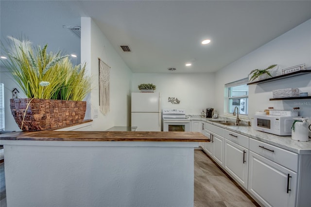 kitchen with white cabinets, white appliances, and sink