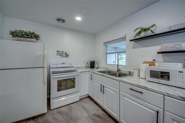 kitchen featuring sink, white cabinets, and white appliances