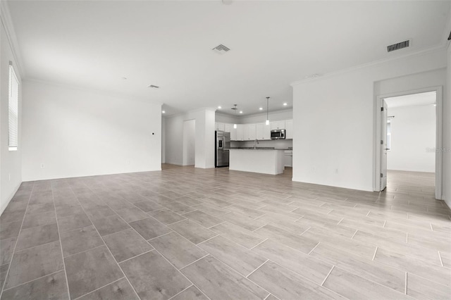 unfurnished living room with sink and crown molding