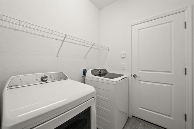 laundry room featuring separate washer and dryer and light tile patterned floors