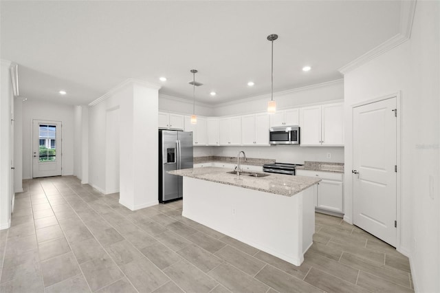 kitchen with appliances with stainless steel finishes, light stone counters, sink, white cabinetry, and an island with sink