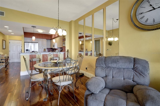 dining room featuring an inviting chandelier and dark hardwood / wood-style floors