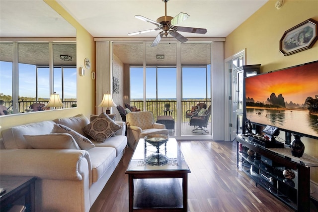 living room featuring floor to ceiling windows, a healthy amount of sunlight, ceiling fan, and dark wood-type flooring