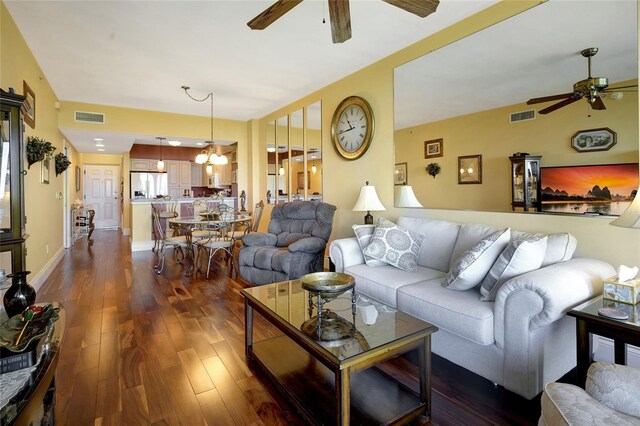 living room featuring ceiling fan and dark wood-type flooring