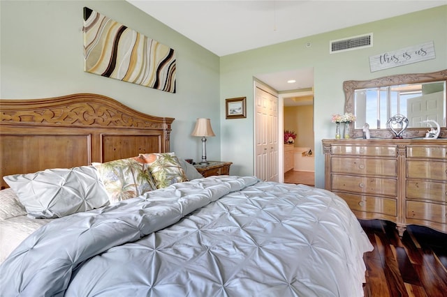 bedroom with dark hardwood / wood-style flooring, ensuite bathroom, and a closet