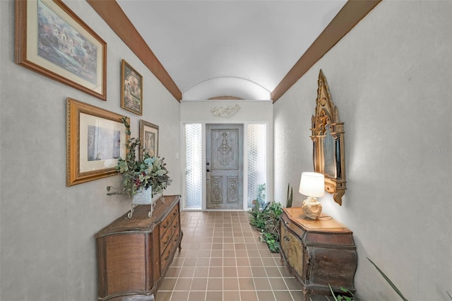 tiled foyer featuring vaulted ceiling