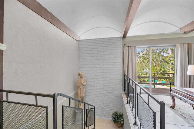 stairway with tile patterned flooring and vaulted ceiling with beams