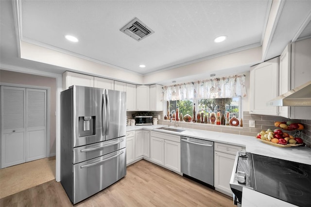 kitchen featuring stainless steel appliances, sink, white cabinetry, and light hardwood / wood-style floors