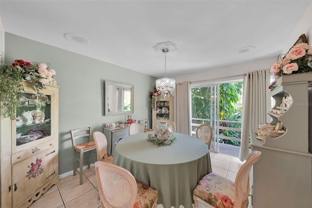 tiled dining room featuring plenty of natural light and a notable chandelier