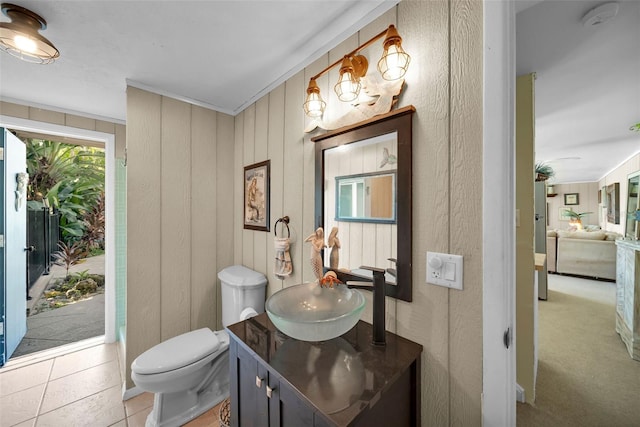 bathroom featuring tile patterned floors, toilet, crown molding, and vanity