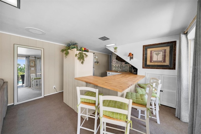 carpeted dining space featuring indoor wet bar