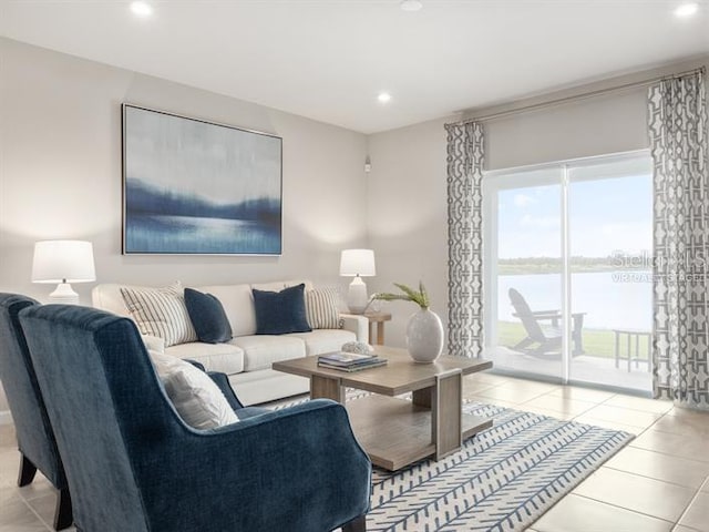 living room featuring a water view and light tile patterned flooring