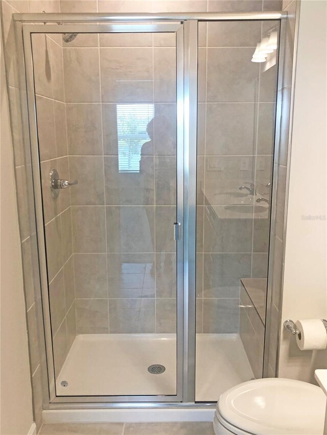 bathroom with an enclosed shower and toilet