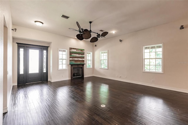 unfurnished living room with ceiling fan and dark hardwood / wood-style flooring