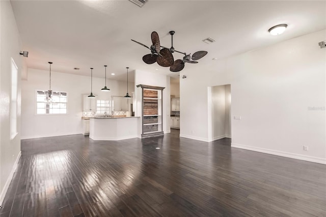 unfurnished living room with ceiling fan and dark wood-type flooring