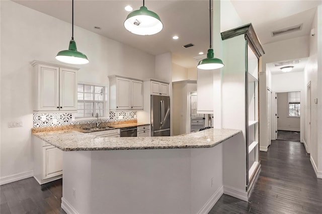 kitchen featuring white cabinetry, kitchen peninsula, and appliances with stainless steel finishes