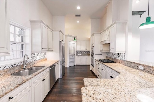 kitchen featuring dark wood-type flooring, white cabinets, pendant lighting, stainless steel appliances, and sink