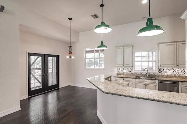 kitchen featuring light stone counters, pendant lighting, sink, stainless steel dishwasher, and french doors