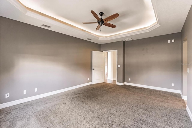 carpeted empty room featuring ceiling fan and a tray ceiling