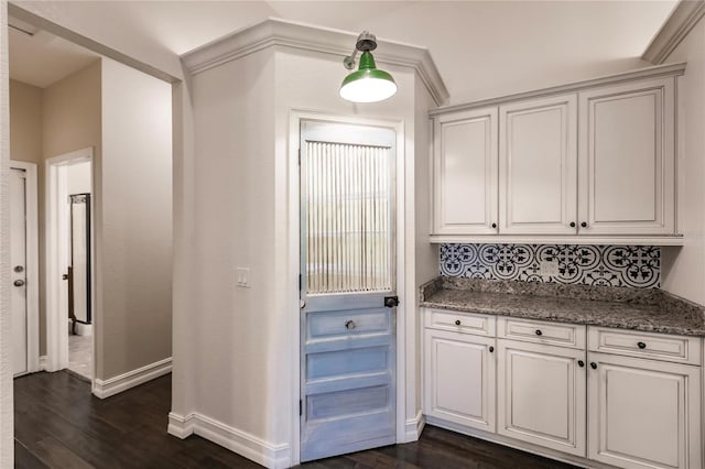 kitchen with backsplash, dark stone countertops, dark hardwood / wood-style flooring, and white cabinets