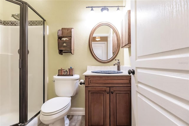 bathroom with walk in shower, vanity, and toilet