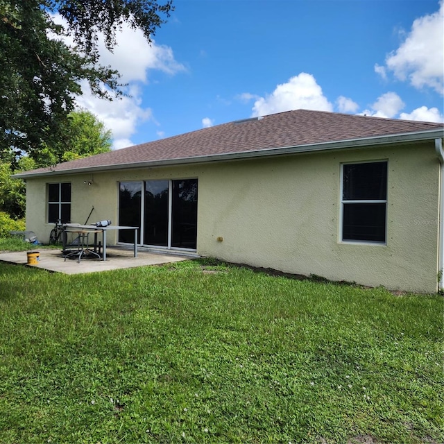 rear view of property featuring a patio area and a lawn