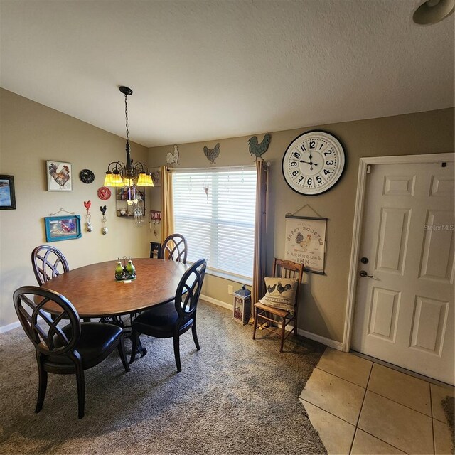 tiled dining space with a textured ceiling, vaulted ceiling, and a chandelier