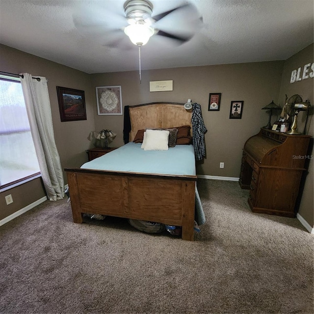 carpeted bedroom with ceiling fan and a textured ceiling