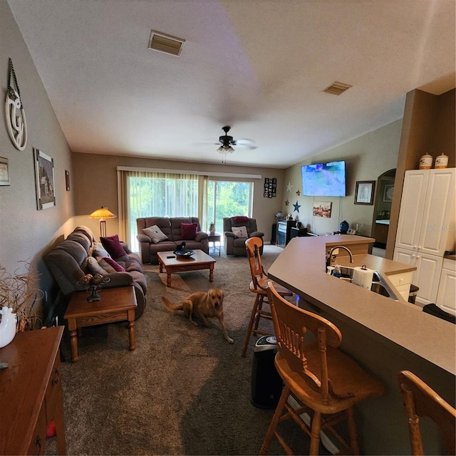 living room featuring a textured ceiling, dark carpet, ceiling fan, and sink