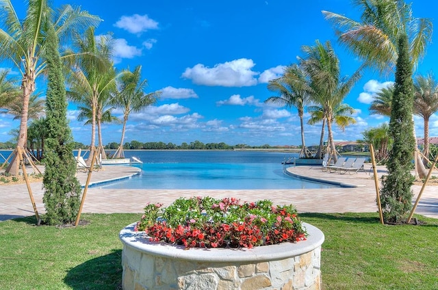 view of pool with a water view and a yard