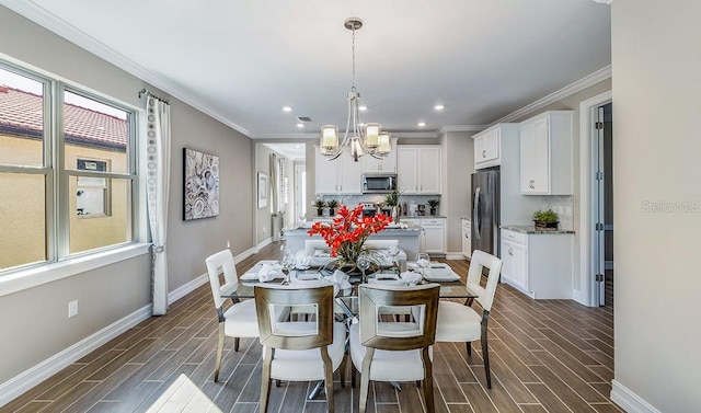 dining space with crown molding and a chandelier