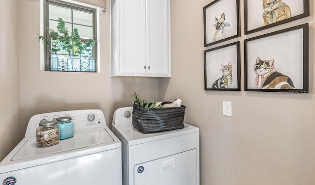 clothes washing area with washing machine and dryer and cabinets