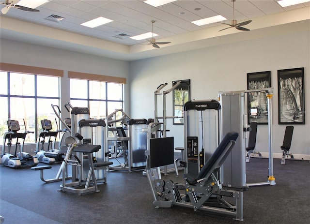 exercise room with a towering ceiling, plenty of natural light, and ceiling fan