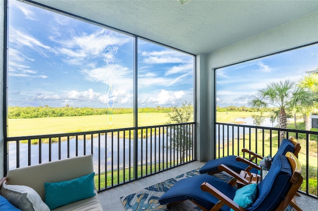 sunroom / solarium featuring a water view