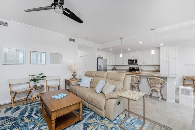 tiled living room with crown molding, ceiling fan, and sink