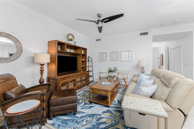 living room with ornamental molding and ceiling fan