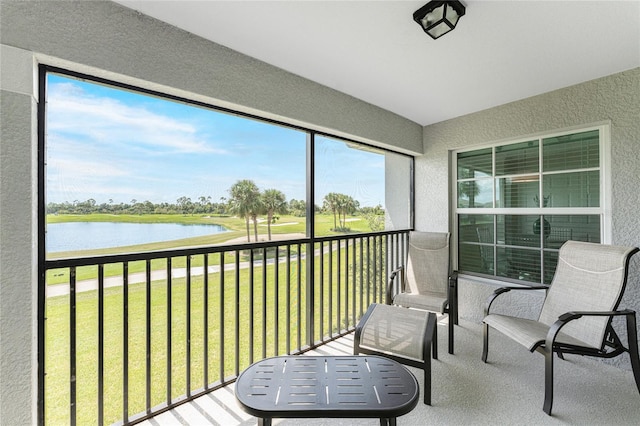 sunroom featuring a water view