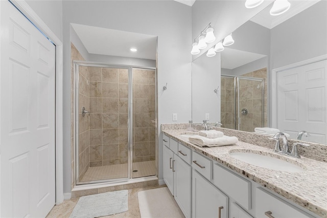 bathroom featuring tile patterned flooring, an enclosed shower, and vanity