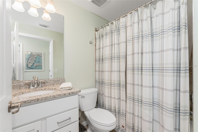 bathroom featuring curtained shower, vanity, and toilet