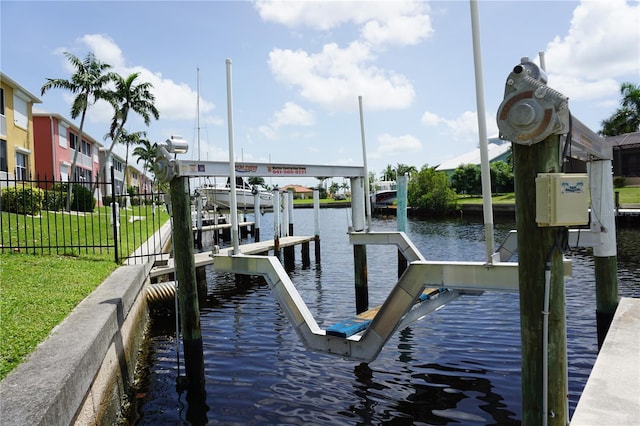 view of dock with a yard and a water view