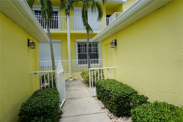 entrance to property with covered porch and a balcony