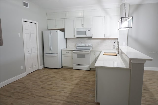 kitchen featuring pendant lighting, white appliances, dark hardwood / wood-style flooring, and sink