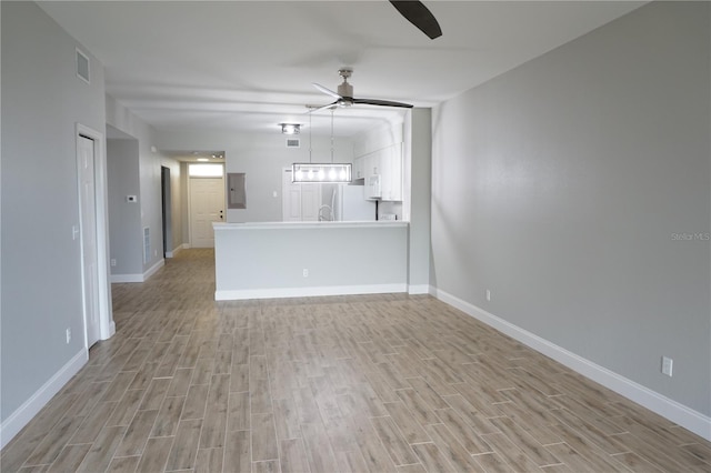 unfurnished living room featuring light wood-type flooring, ceiling fan, and electric panel