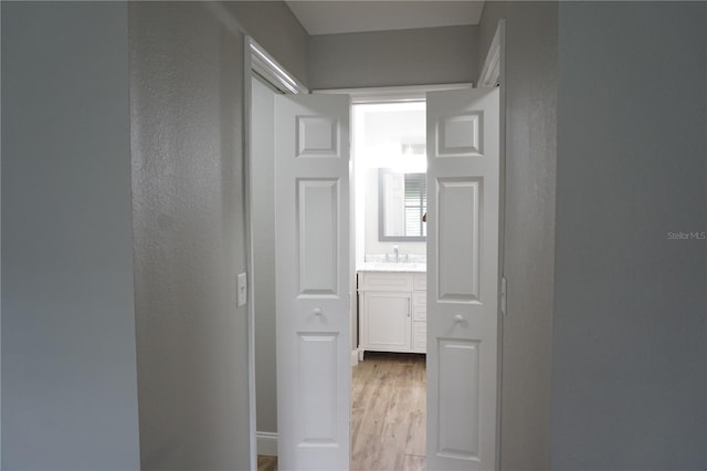 corridor featuring light hardwood / wood-style floors and sink