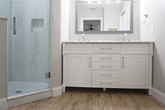 bathroom with vanity, hardwood / wood-style flooring, and a shower with door