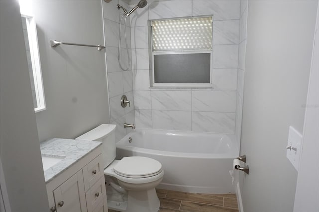 full bathroom with hardwood / wood-style floors, toilet, tiled shower / bath combo, and vanity