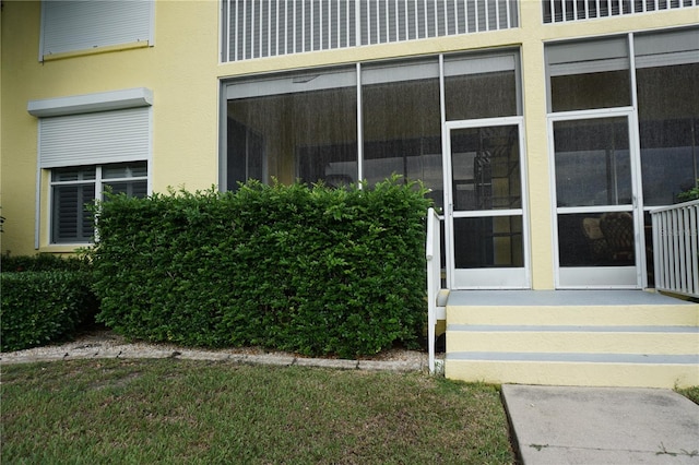 entrance to property featuring a yard