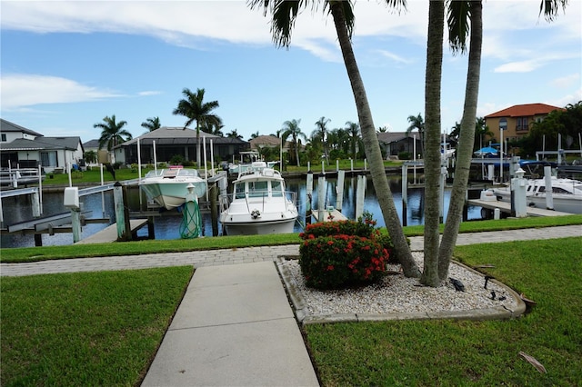 view of dock with glass enclosure, a water view, and a yard