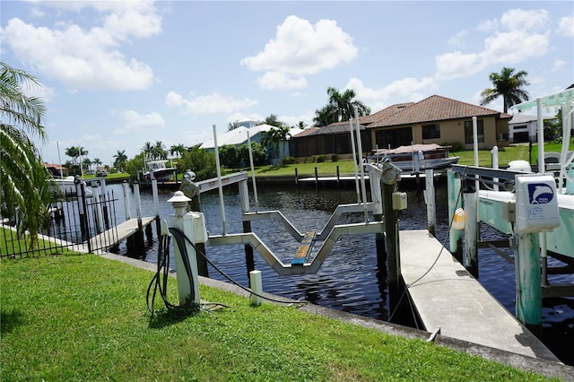 view of dock featuring a water view and a yard